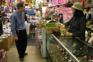 FEW CUSTOMERS: Maisie Wong (right) talk to his husband, Check Chew Ng as two customers take a look at goods in their store. Wong said her store sales continued to plunge, so she had no choices but to fire all her two employees. (Moch. N. Kurniawan)  