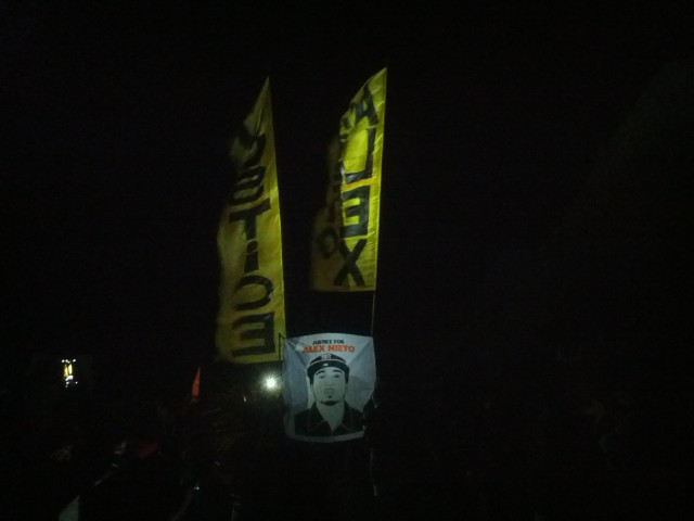 Banners raised behind image of Alex Nieto as march concluded on Bernal Hill. Photo by Daniel Hirsch.