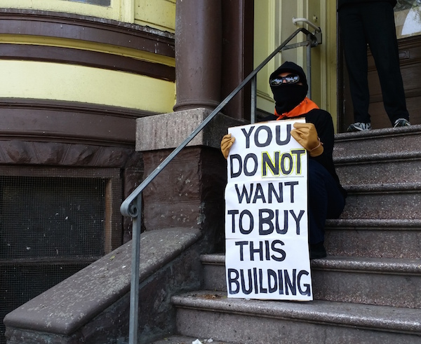 Activist sits on steps of the Pigeon Palace. Photo by Daniel Hirsch.