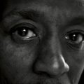 Close-up, black-and-white portrait of a person’s face focusing on their eyes.