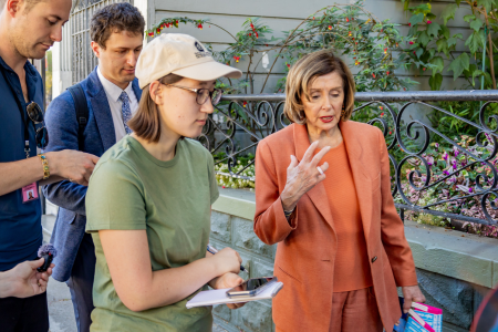 A reporter takes notes during an interview outside.